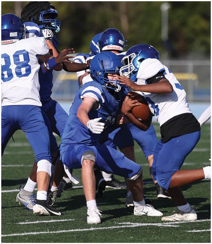 A group of football players wearing black and white uniforms. Description generated by AI