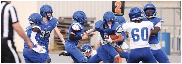 A group of football players on a field. Description generated by AI