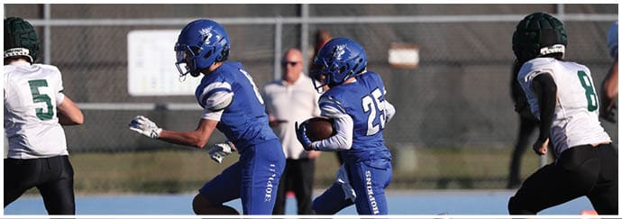 A group of football players on a field. Description generated by AI