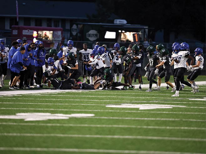 A group of football players in black and white uniforms are on the field. AI generated content
