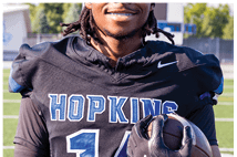 A young man wearing a white jersey with the number 10 on it. Description generated by AI