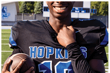 A young man wearing a white jersey with the number 10 on it. Description generated by AI