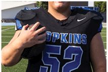 A young man wearing a white jersey with the number 10 on it. Description generated by AI