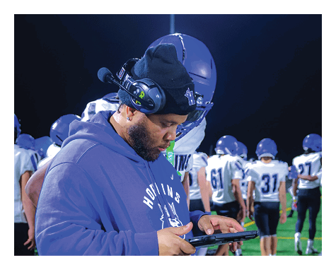 A man wearing a football uniform is jumping to catch a football. AI generated content
