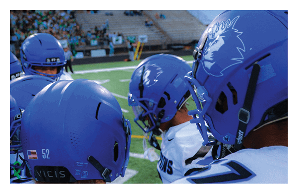 A group of people are kneeling on a field, possibly in a football game. AI generated content