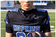 A young man wearing a white jersey with the number 10 on it. Description generated by AI