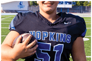 A young man wearing a white jersey with the number 10 on it. Description generated by AI