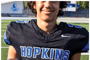 A young man wearing a white jersey with the number 10 on it. Description generated by AI