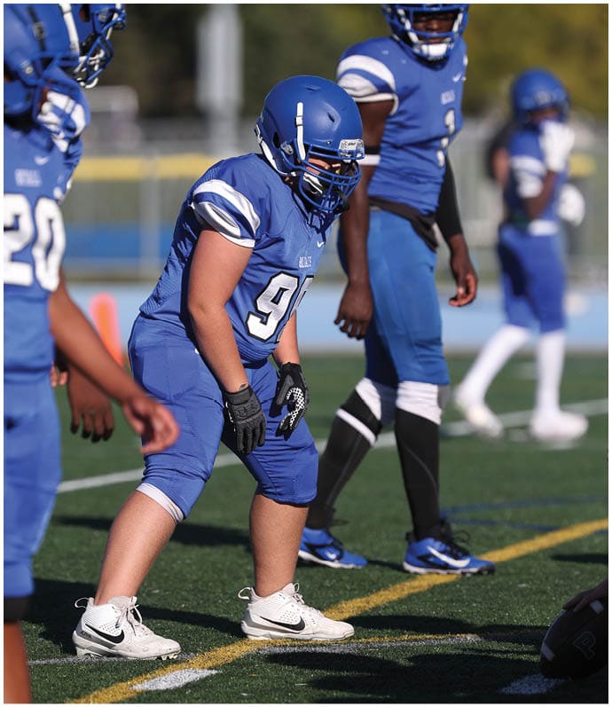 A group of football players wearing black and white uniforms. Description generated by AI