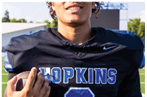A young man wearing a white jersey with the number 10 on it. Description generated by AI
