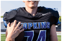A young man wearing a white jersey with the number 10 on it. Description generated by AI