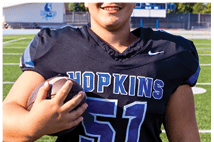 A young man wearing a white jersey with the number 10 on it. Description generated by AI