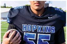 A young man wearing a white jersey with the number 10 on it. Description generated by AI
