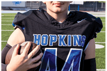 A young man wearing a white jersey with the number 10 on it. Description generated by AI