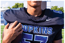 A young man wearing a white jersey with the number 10 on it. Description generated by AI