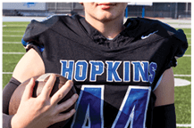 A young man wearing a white jersey with the number 10 on it. Description generated by AI