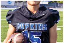 A young man wearing a white jersey with the number 10 on it. Description generated by AI