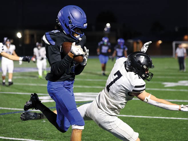 A group of football players in black and white uniforms are on the field. AI generated content