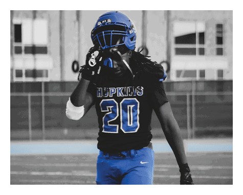 A man wearing a football uniform is jumping to catch a football. AI generated content