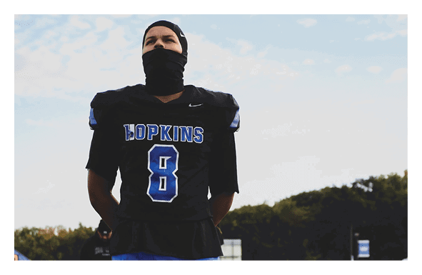 A group of football players wearing headphones and smiling. AI generated content