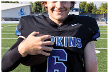 A young man wearing a white jersey with the number 10 on it. Description generated by AI