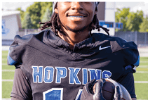 A young man wearing a white jersey with the number 10 on it. Description generated by AI
