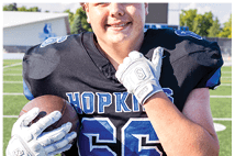 A young man wearing a white jersey with the number 10 on it. Description generated by AI