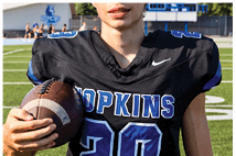 A young man wearing a white jersey with the number 10 on it. Description generated by AI