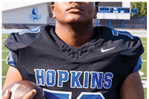 A young man wearing a white jersey with the number 10 on it. Description generated by AI