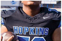 A young man wearing a white jersey with the number 10 on it. Description generated by AI