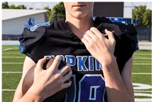 A young man wearing a white jersey with the number 10 on it. Description generated by AI