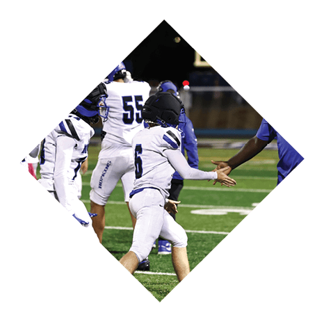 A football player wearing a black jersey with the number 3 kneels on the field. AI generated content