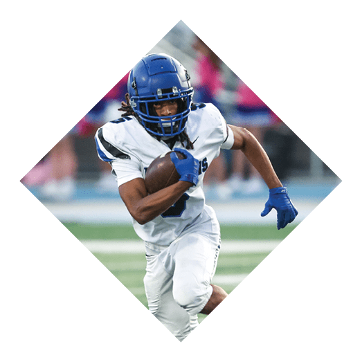 A football player wearing a black jersey with the number 10 sits on the ground with a football helmet on the ground next to him. AI generated content