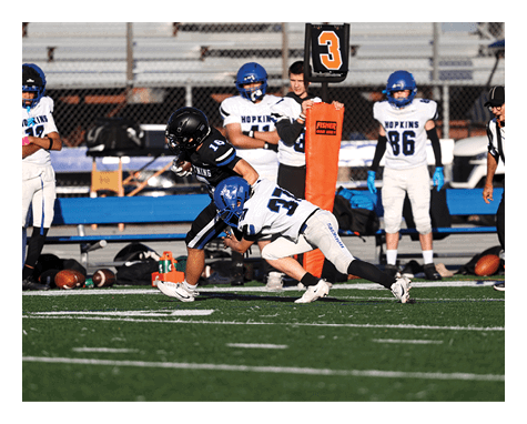 A man wearing a football uniform is jumping to catch a football. AI generated content