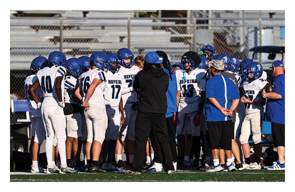 A group of people are kneeling on a field, possibly in a football game. AI generated content