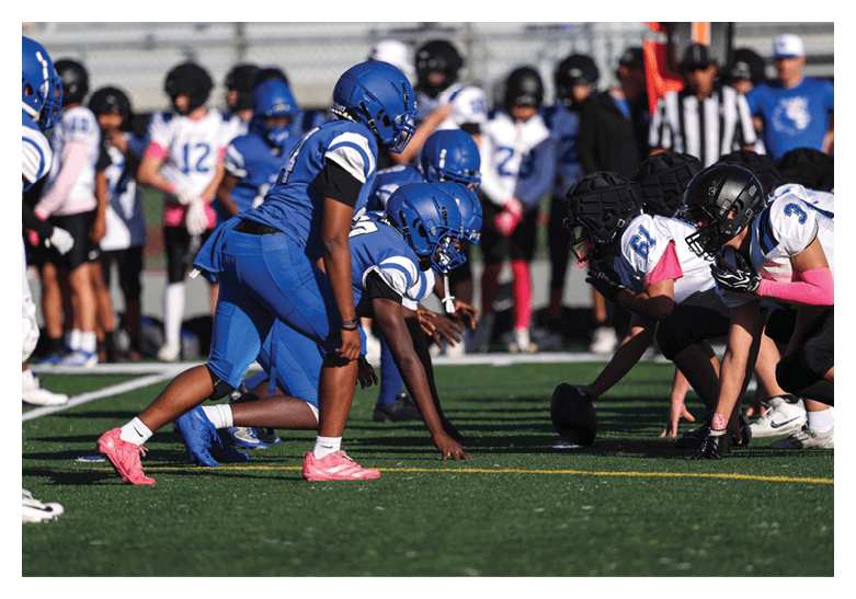 A group of football players on a field, one of them is running with a football. AI generated content