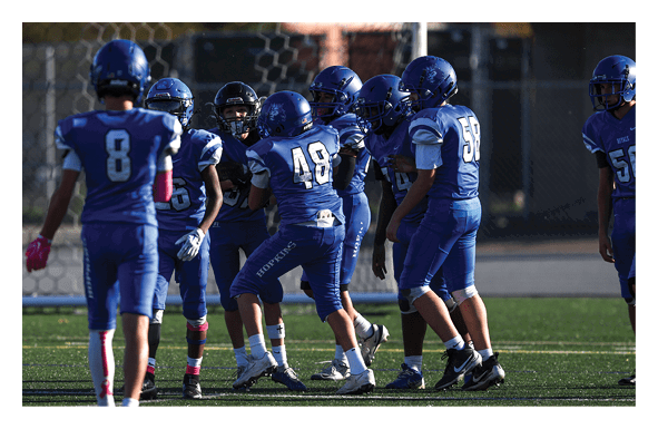 A group of people are kneeling on a field, possibly in a football game. AI generated content