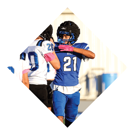A football player wearing a black jersey with the number 10 sits on the ground with a football helmet on the ground next to him. AI generated content