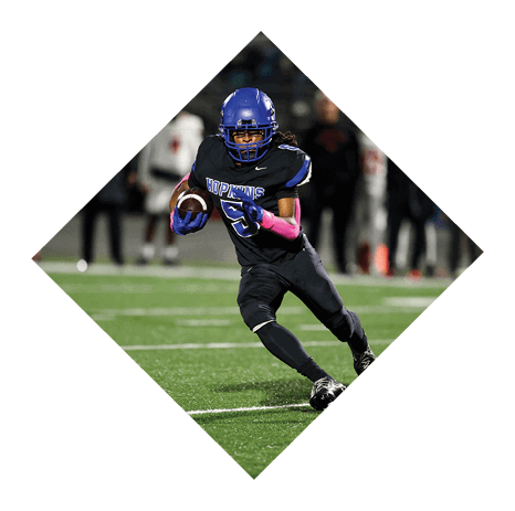 A football player wearing a black jersey with the number 3 kneels on the field. AI generated content