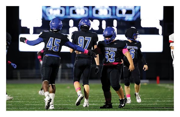 A group of football players wearing headphones and smiling. AI generated content