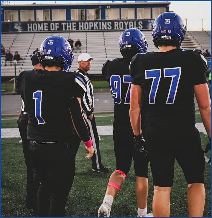 A group of football players wearing black and white uniforms. Description generated by AI