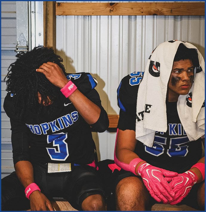A group of football players wearing black and white uniforms. Description generated by AI