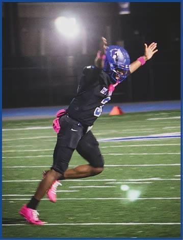 A football player running on the field. Description generated by AI