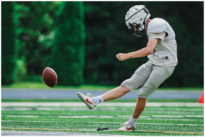 A group of football players wearing black and white uniforms. Description generated by AI