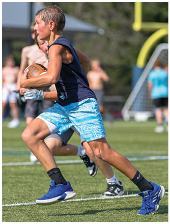 A football player running on the field. Description generated by AI