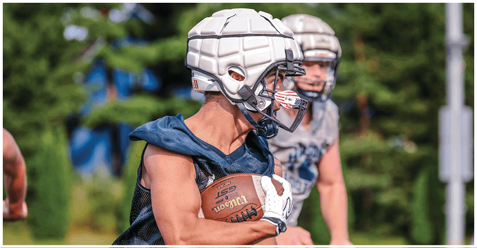 A group of football players wearing black and white uniforms. Description generated by AI