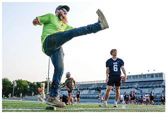 A football player is sliding on the ground. Description generated by AI