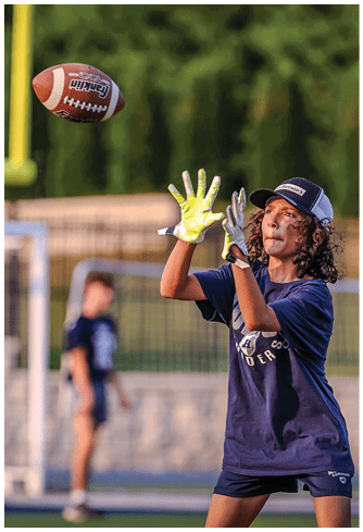 A football player running on the field. Description generated by AI