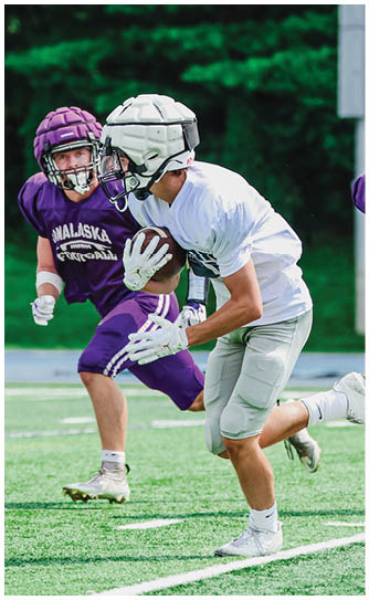 A football player catching a ball. Description generated by AI