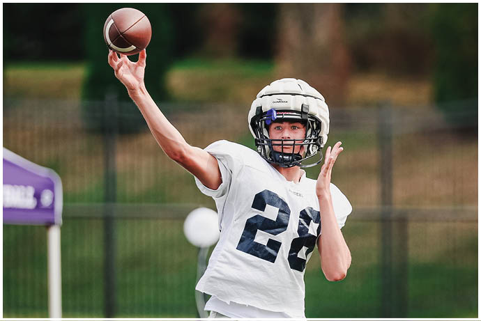 A group of football players wearing black and white uniforms. Description generated by AI